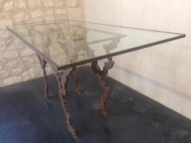Table de verre sur un piétement à volutes en fer