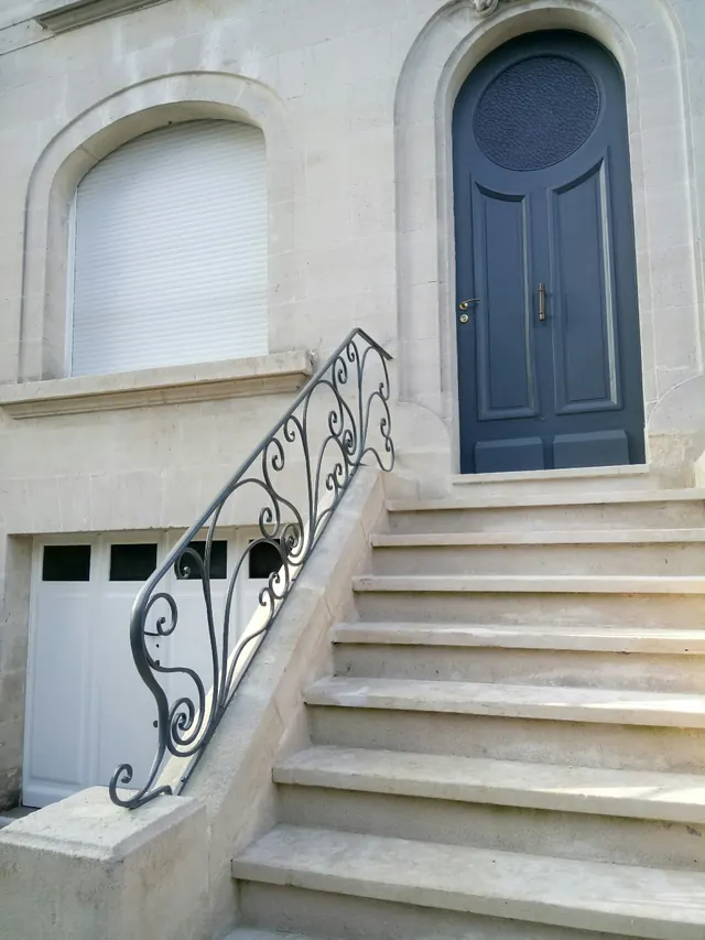 Rampe extérieure à volutes, perron d'une maison