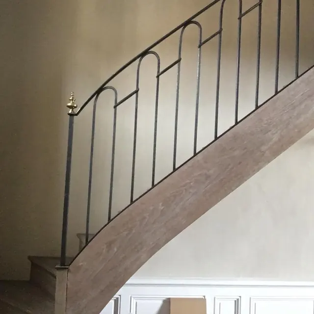Rampe à arceaux sur un escalier tournant en bois