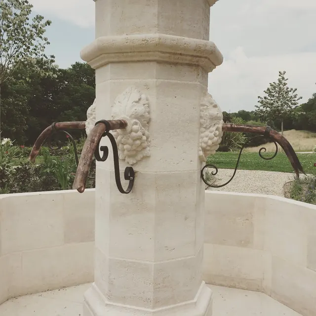 Fontaine en pierre et ses ferrures en fer forgé