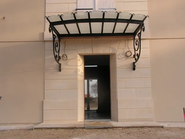 Marquise vitrée en fer forgé au-dessus d'une porte