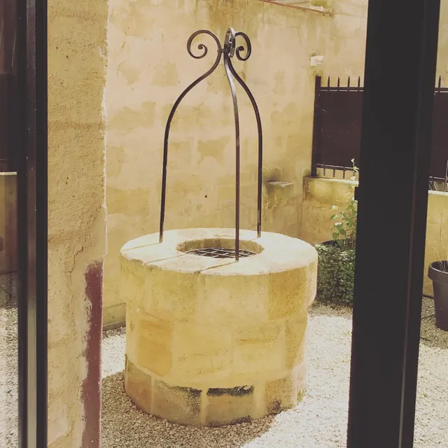 Puits en pierre et son arceau en fer forgé