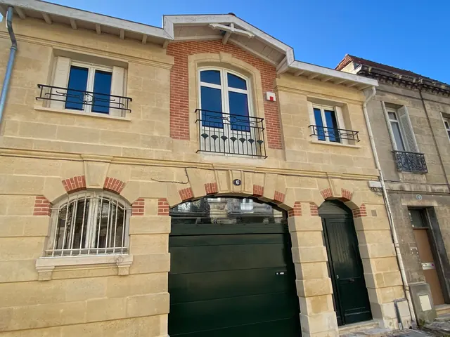 Balconnets en fer forgé sur une façade de brique et de pierre