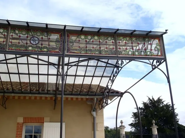 Verrière en fer et vitraux au-dessus d'une terrasse